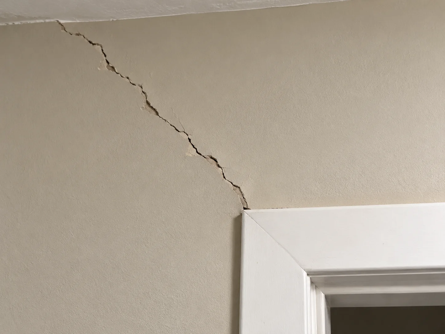 Diagonal settlement cracking around a door frame