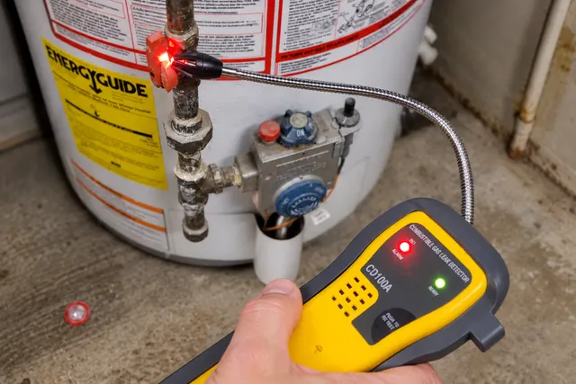 Inspector testing gas piping for a leak